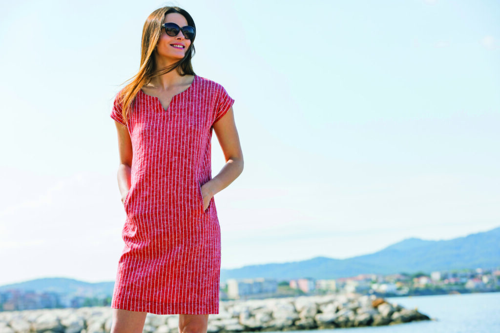 Nouvelle collection de vêtement Bastingage représenté par une femme souriante qui porte une belle robe rose